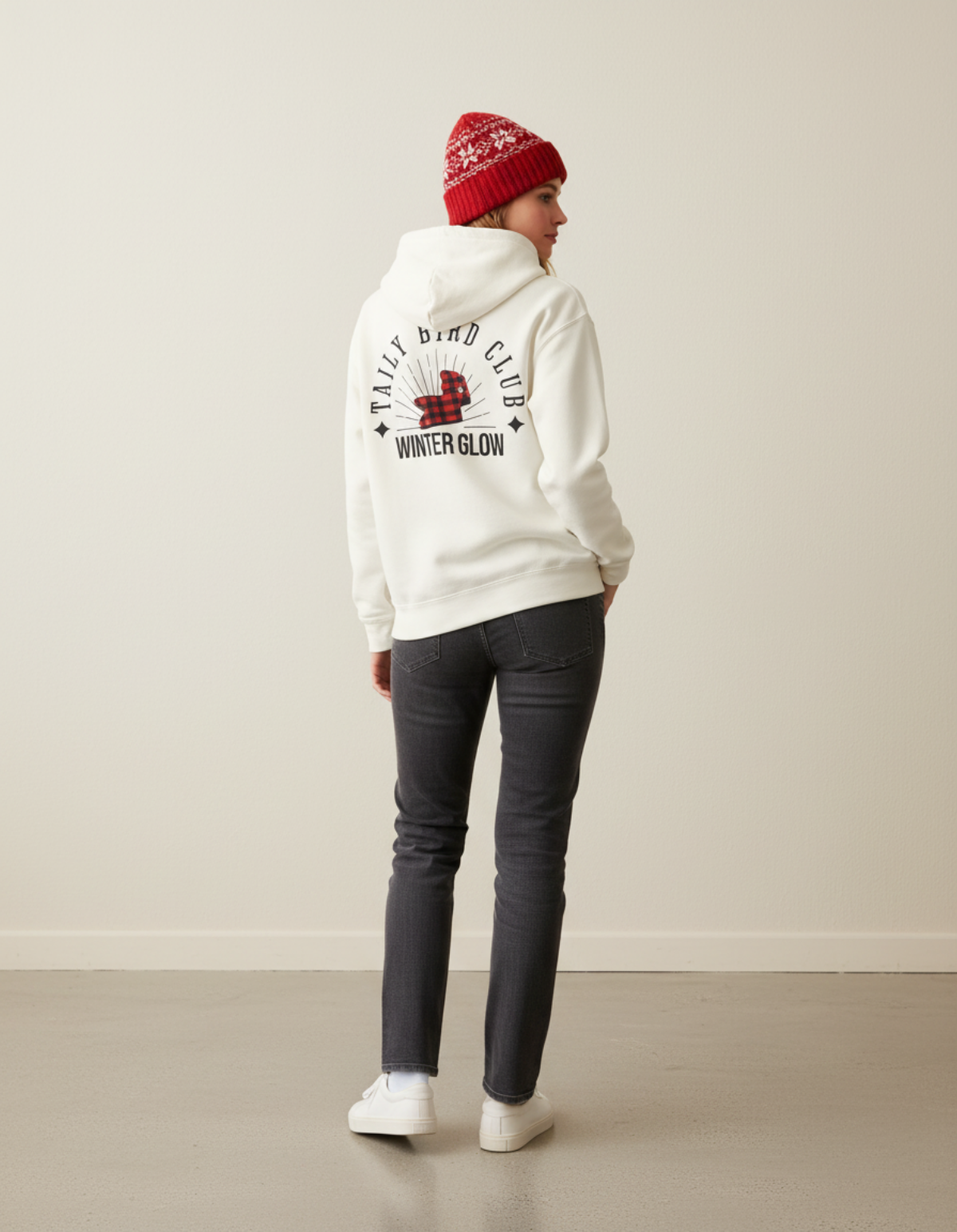 Model wearing Taily Bird Club Winter Glow Hoodie in bone color, showcasing the back graphic and logo.