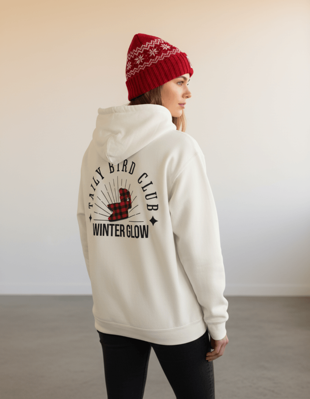 Taily Bird Club Winter Glow Hoodie – Bone worn by a model with red beanie, showcasing vintage graphic design on back.