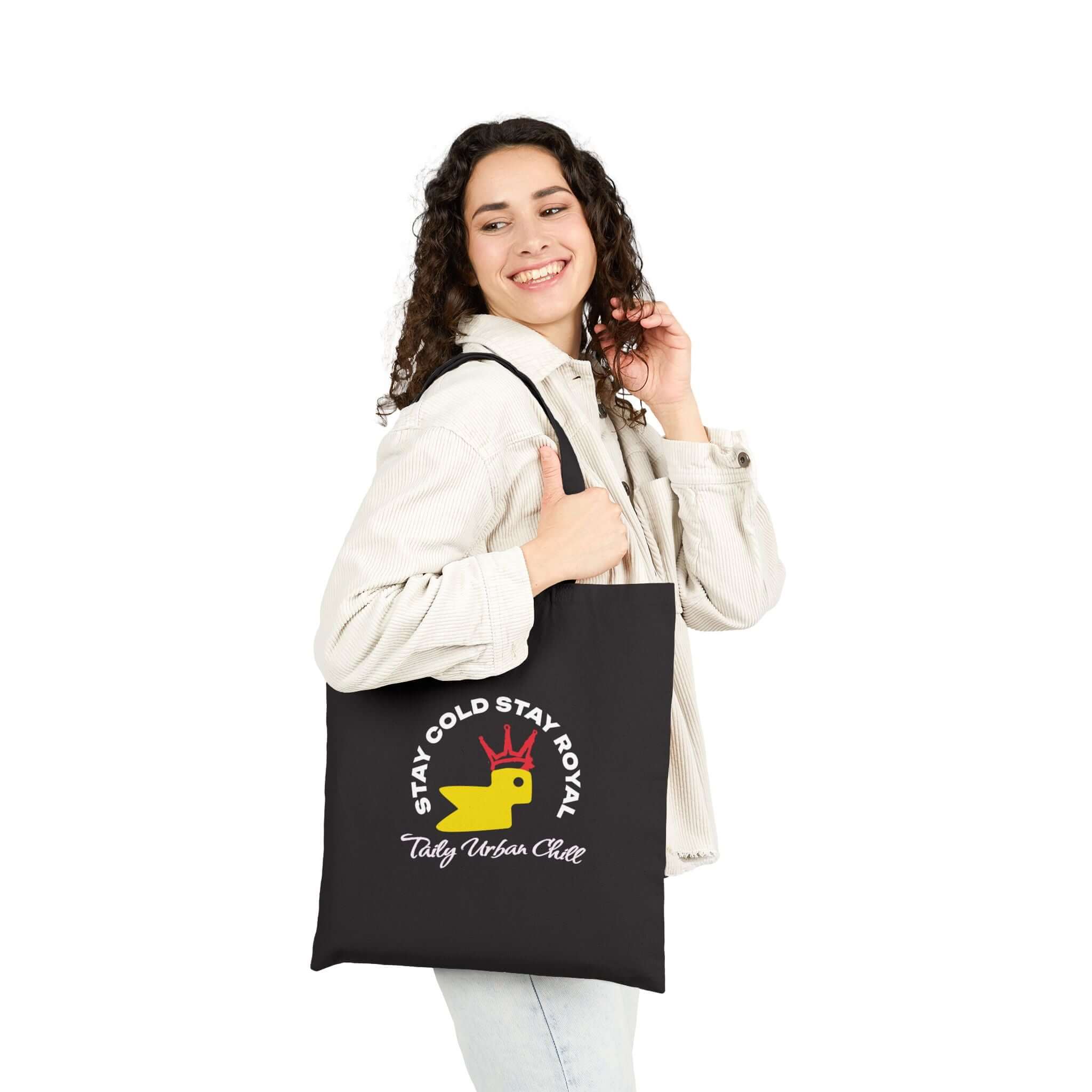Woman holding Taily Bird Bold Canvas Tote Bag featuring logo in black and yellow, ideal for everyday use.