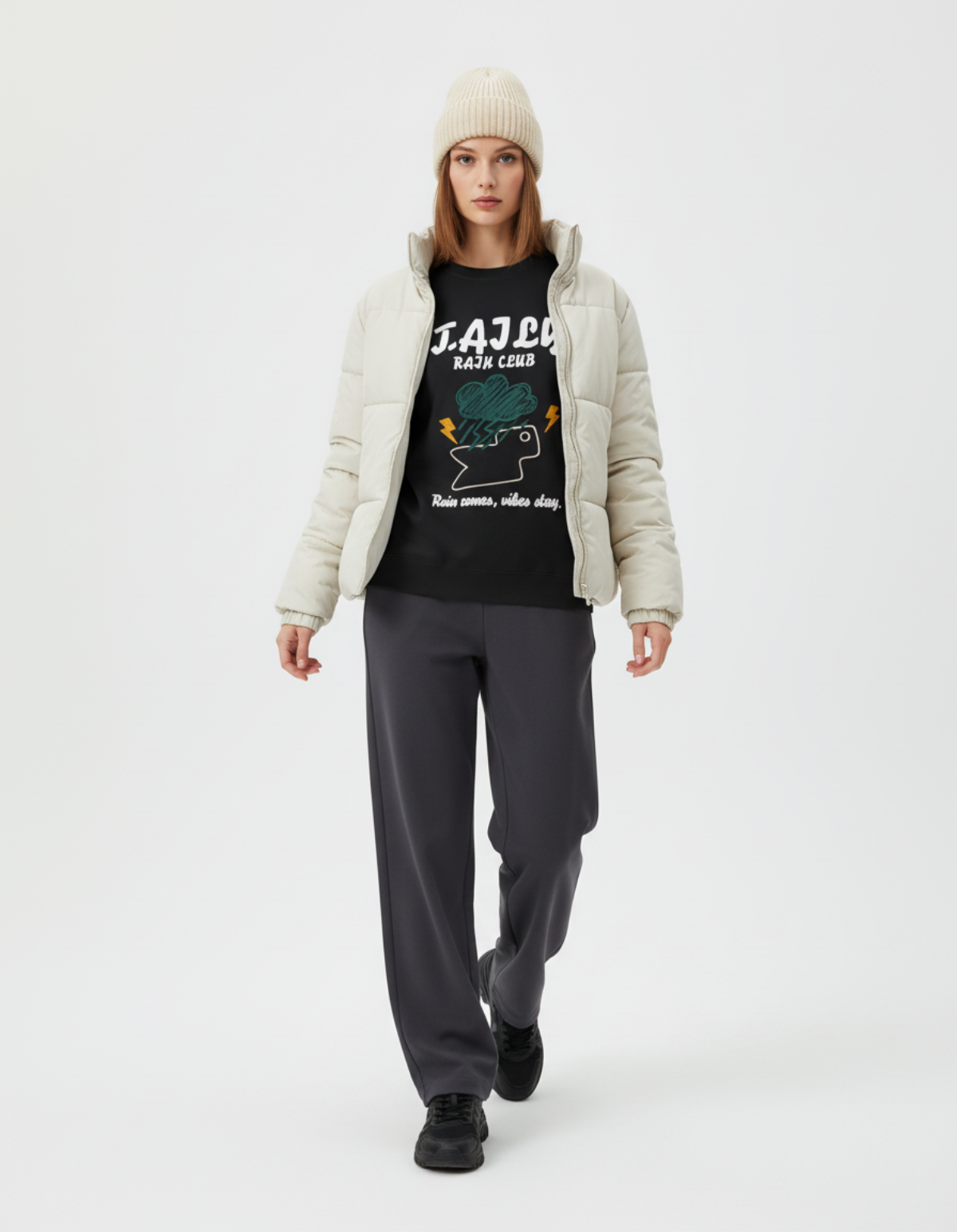 Model wearing Taily Rain Club sweatshirt in black with weather-inspired graphic and light jacket.