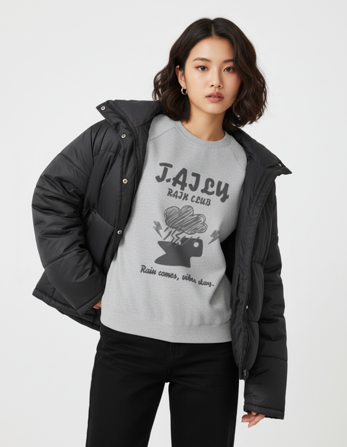 Model wearing a Taily Rain Club sweatshirt in Sport Grey with a graphic design and the phrase 'Rain comes, vibes stay.'