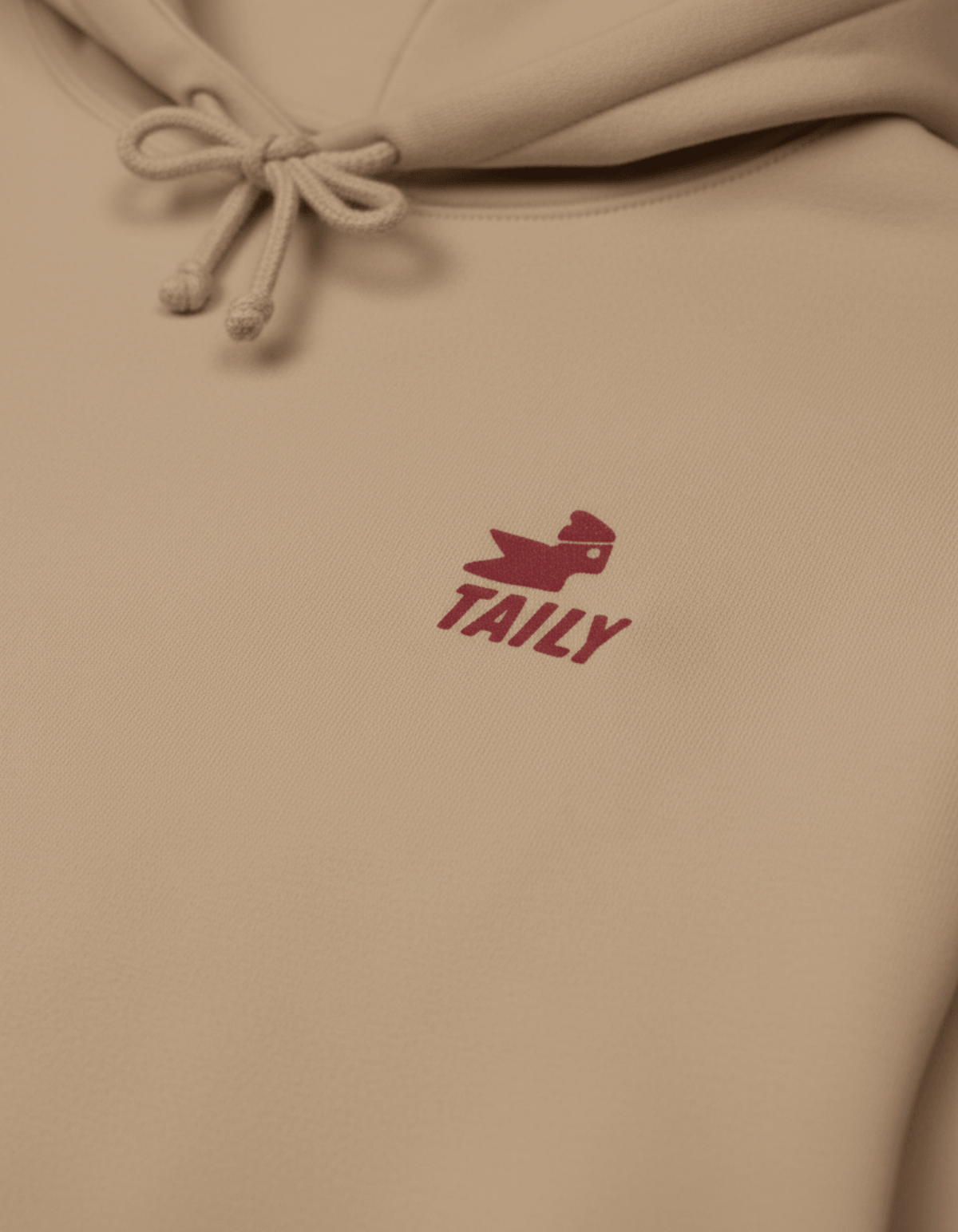Taily Bird Parkland Hoodie – Sandstone with embroidered logo detail in a close-up view.