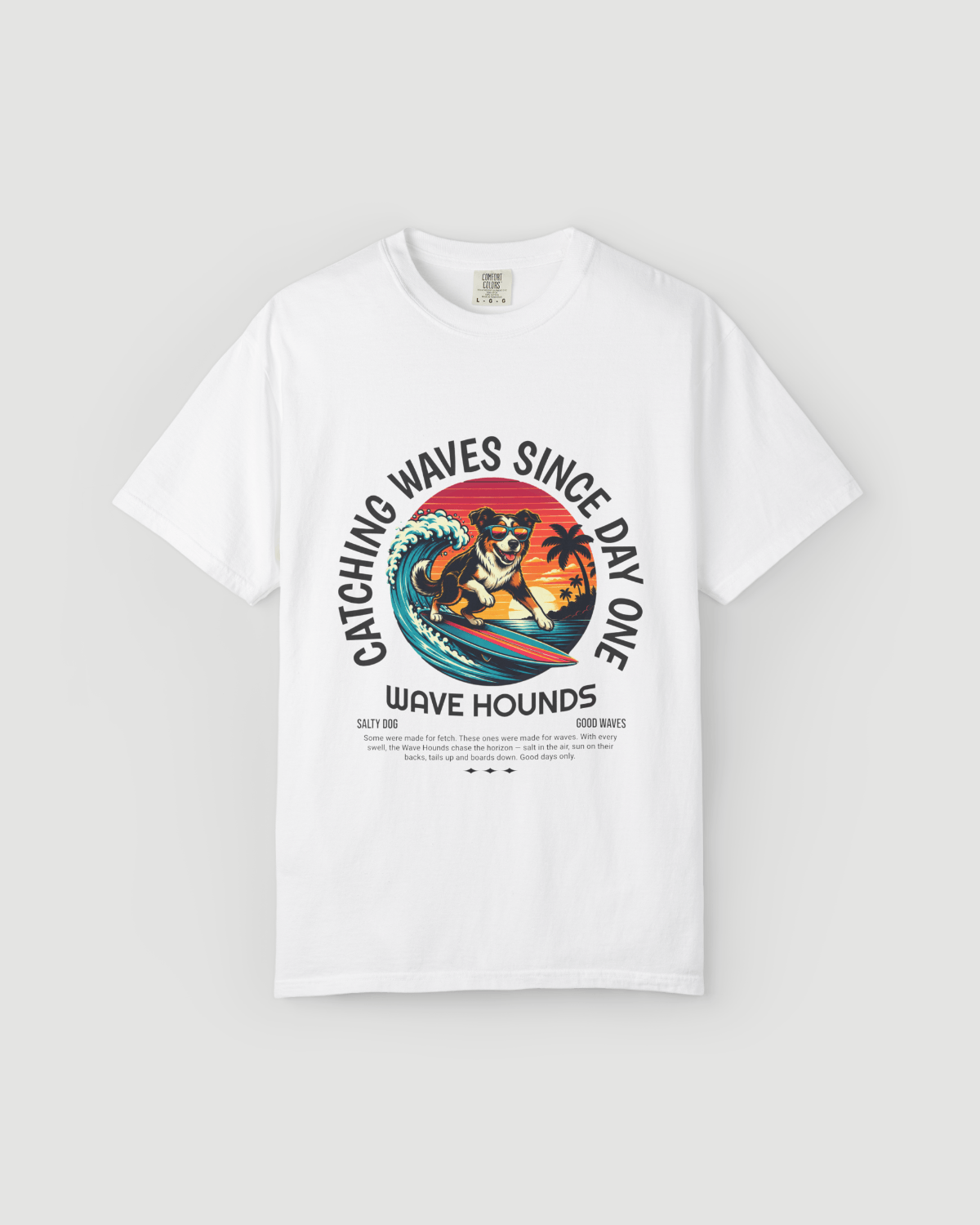 Wave Hounds Surf Tee – White featuring a retro surf graphic with a dog catching waves.