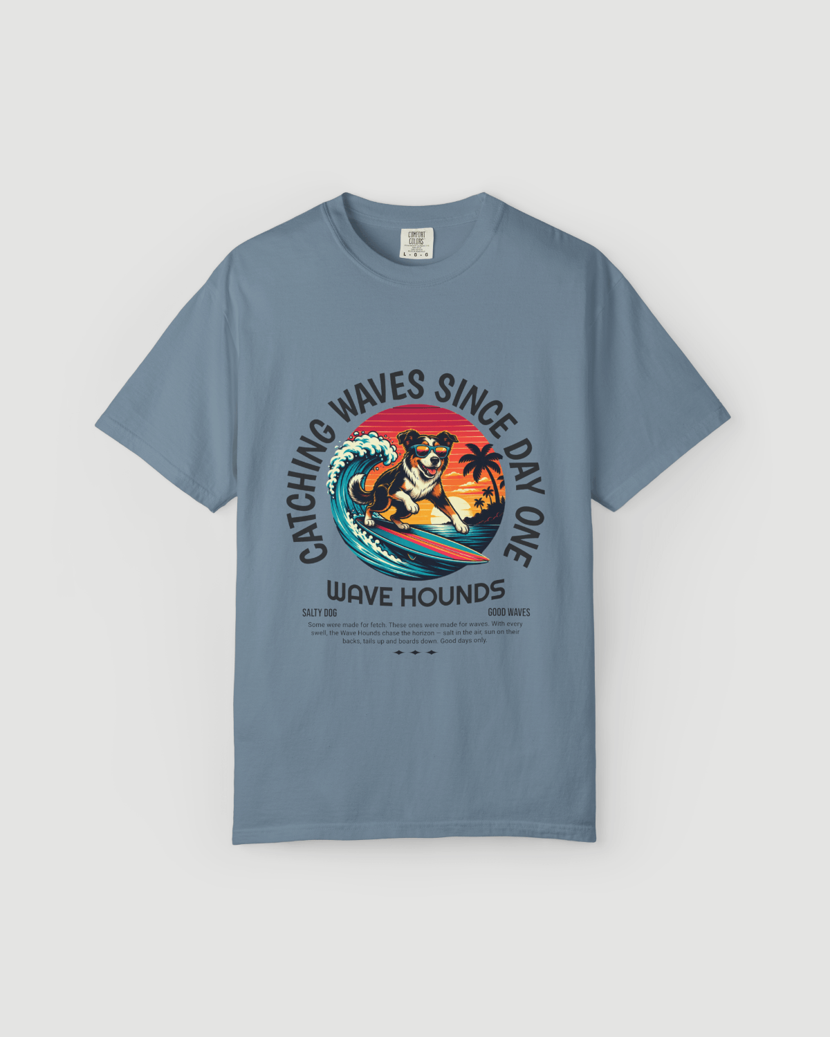 Wave Hounds Surf Tee – Ice Blue featuring retro surf graphic and ocean-inspired color.
