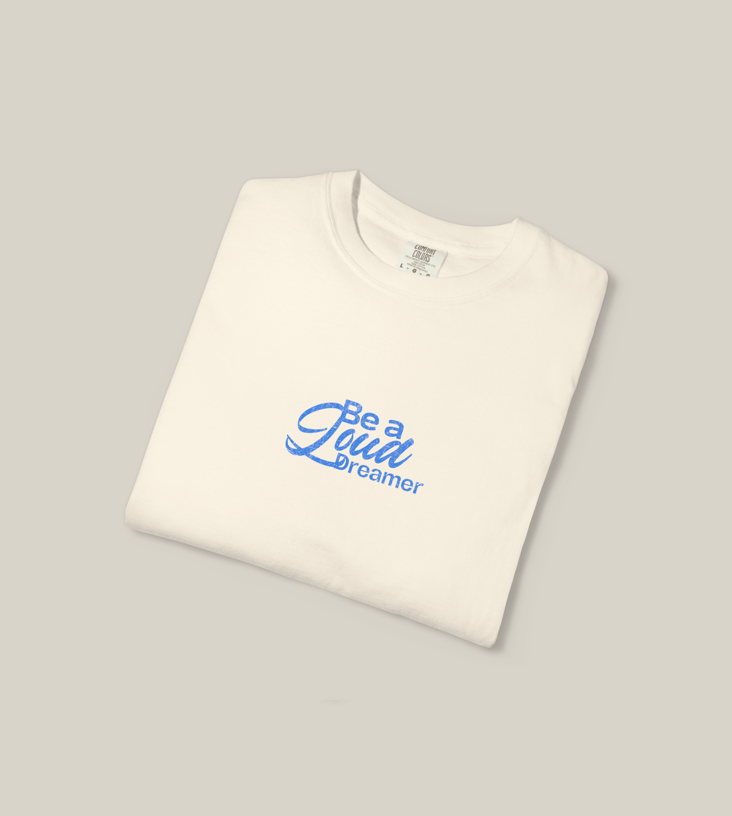 Taily Loud Dreamer streetwear graphic t-shirt in ivory with bold blue lettering, ideal for casual everyday wear.