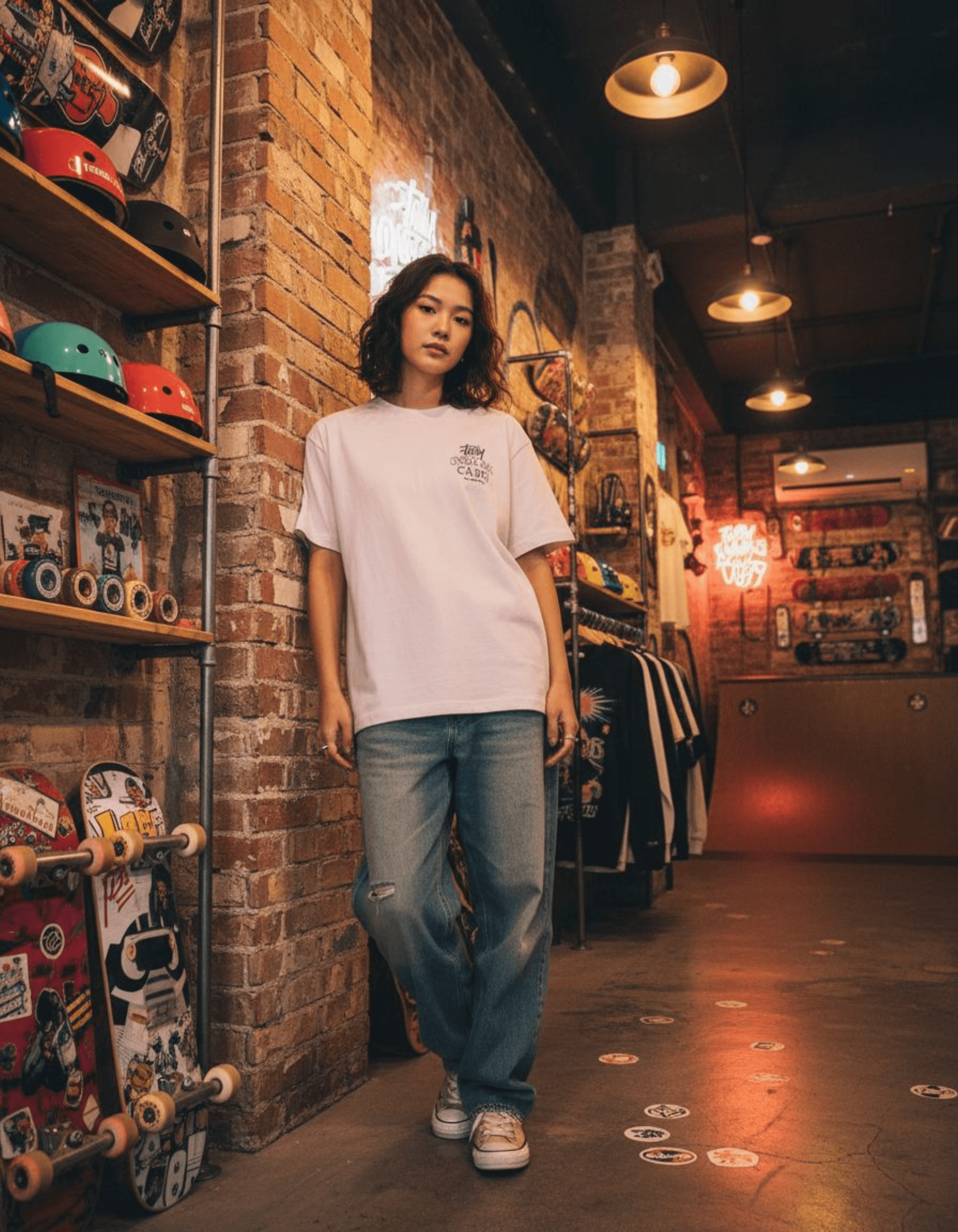 Woman wearing Taily Concrete Waves Taipei Streetwear Boxy T-Shirt in a skate shop with skateboards on display.