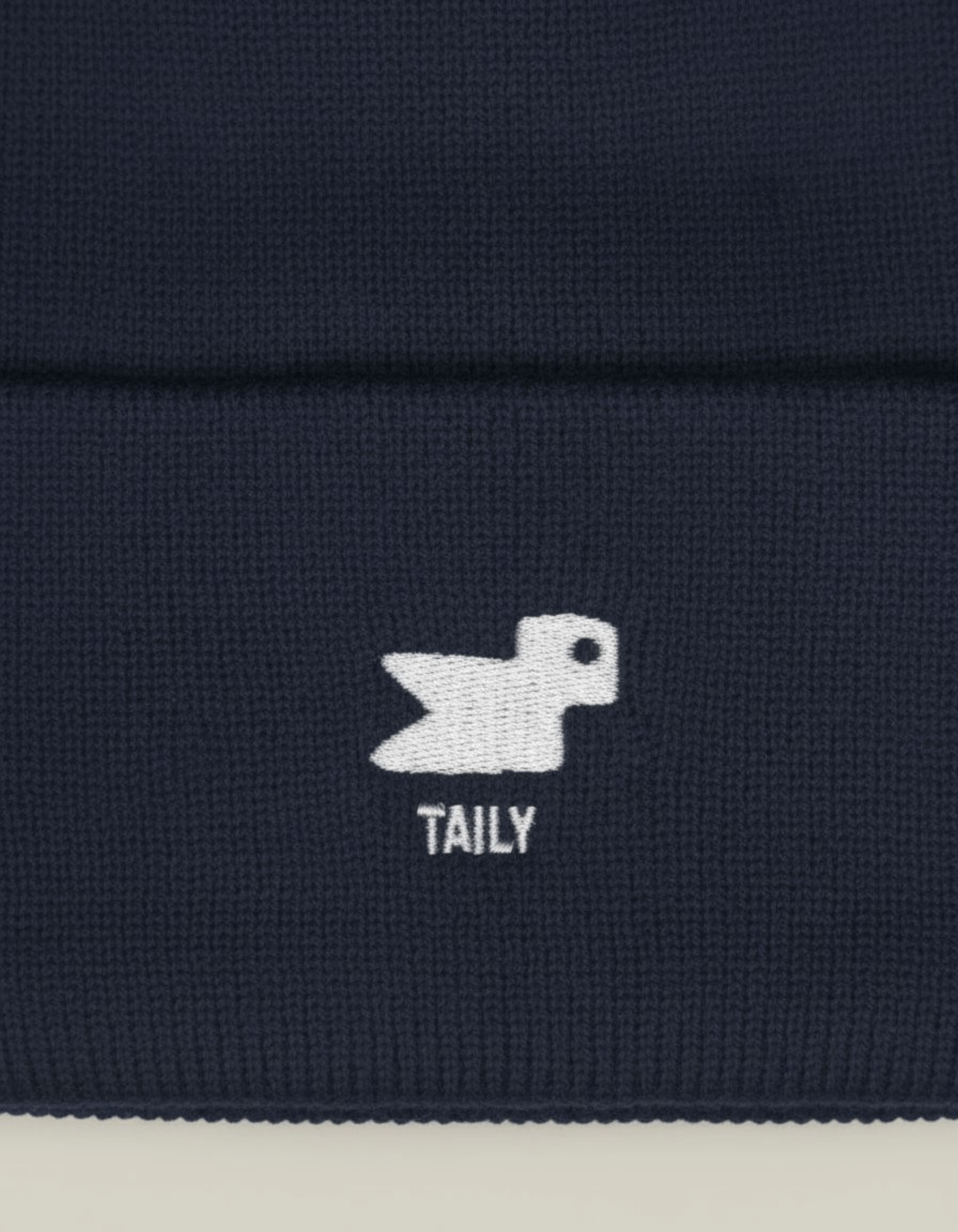 Taily Bird Knit Beanie design featuring minimal embroidery on a dark navy background.