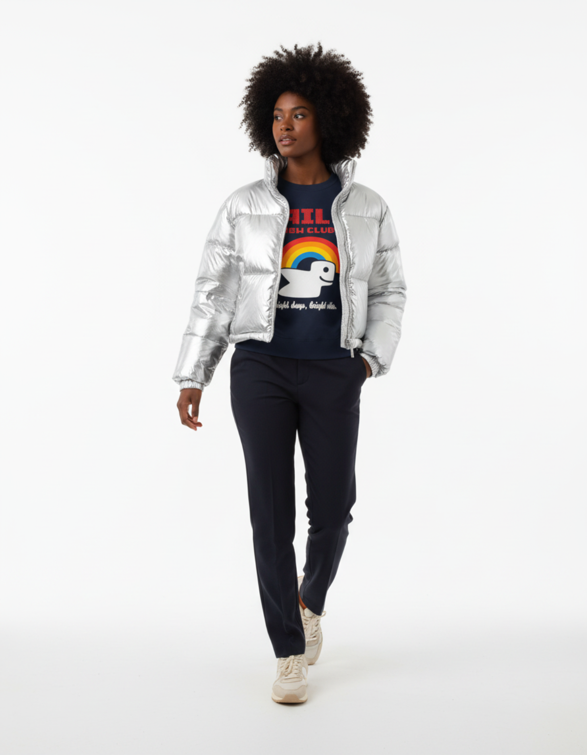 A model wearing the RBW Club sweatshirt in Navy, paired with a silver puffer jacket, stylishly walking.