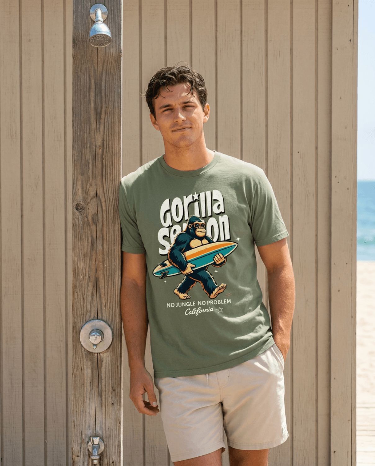 Gorilla Season Surf Tee – Sage worn by a young man at the beach with a surfboard, showing a laid-back California style.
