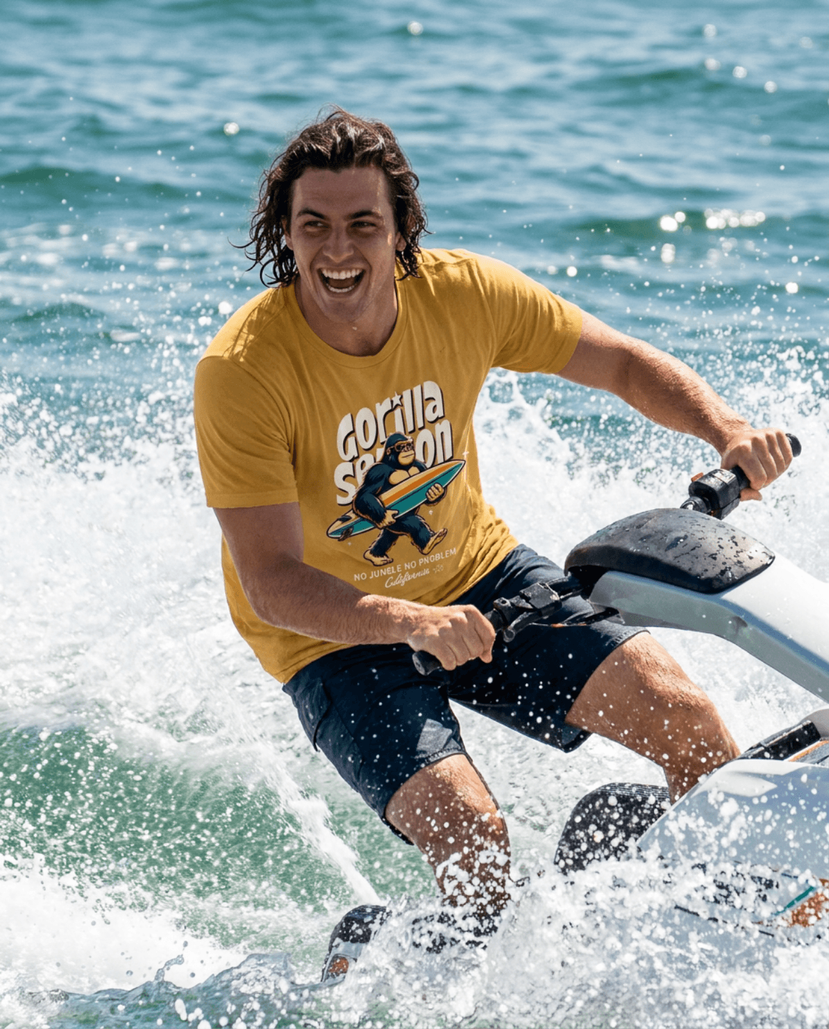 Man riding a jet ski wearing the Gorilla Season Surf Tee – Mustard with a bold California surf graphic.