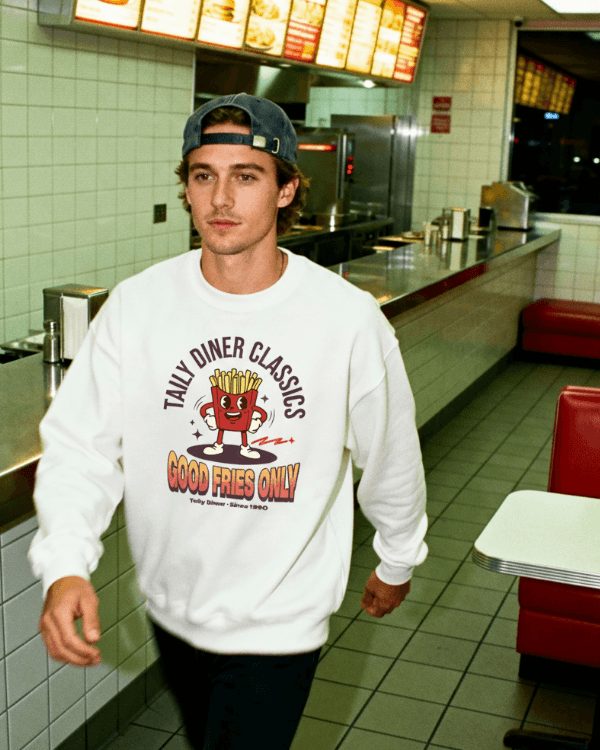 Good Fries Only Sweatshirt – Taily Diner (White) worn by a man in a diner setting.