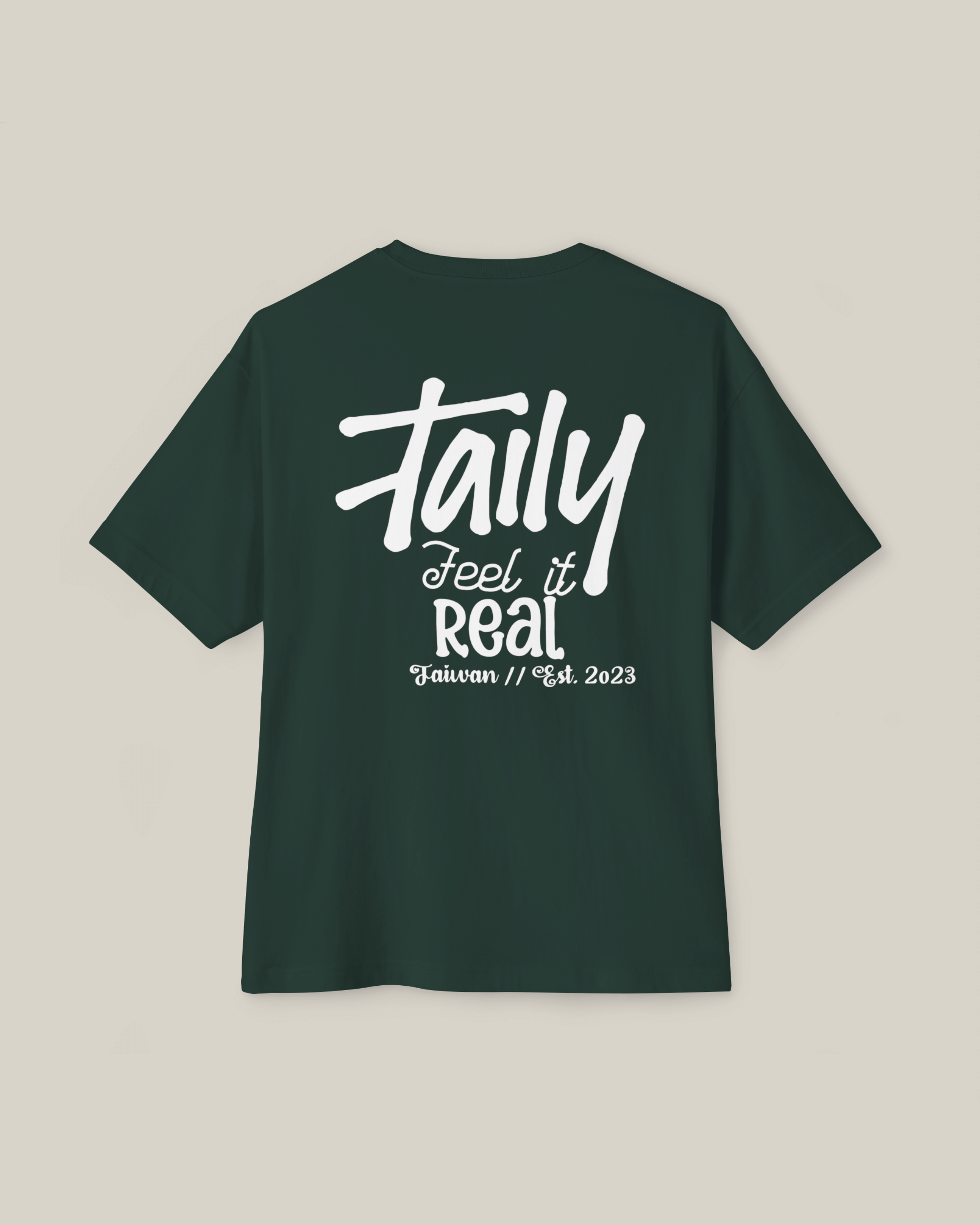 Taily Feel It Real boxy tee in forest green, showcasing chest logo and bold lettering, streetwear boxy t-shirt.