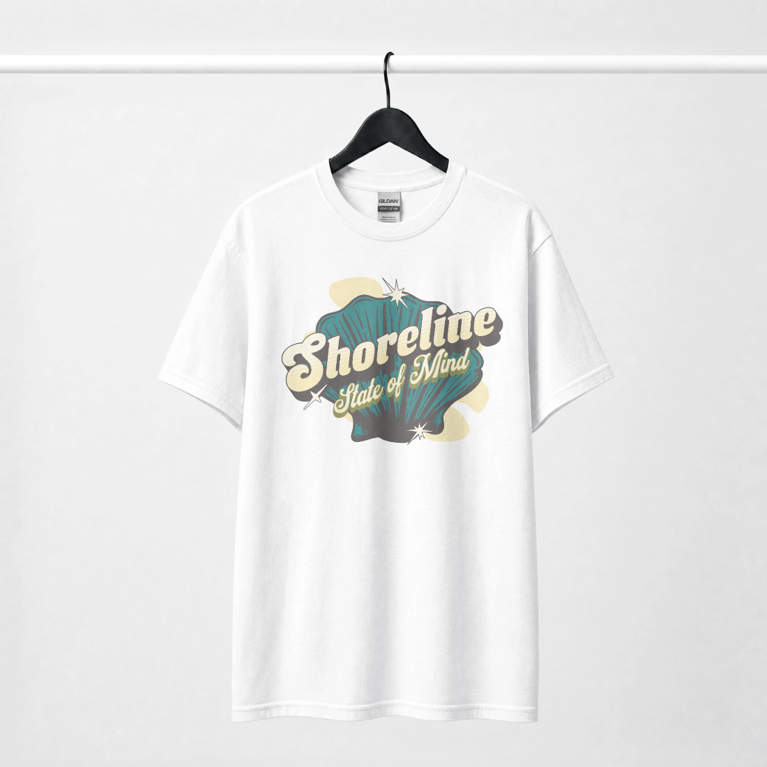 Shoreline State of Mind Tee – White featuring a vintage seashell graphic in deep teal and warm cream.
