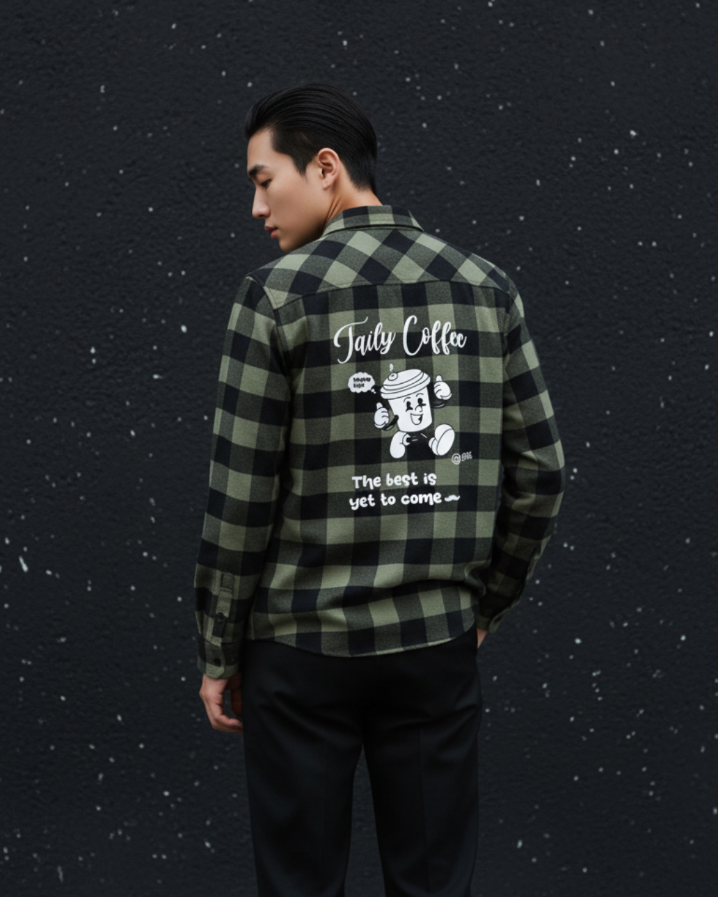 Model wearing Taily Coffee flannel shirt in Olive with playful graphic on the back against a dark background.
