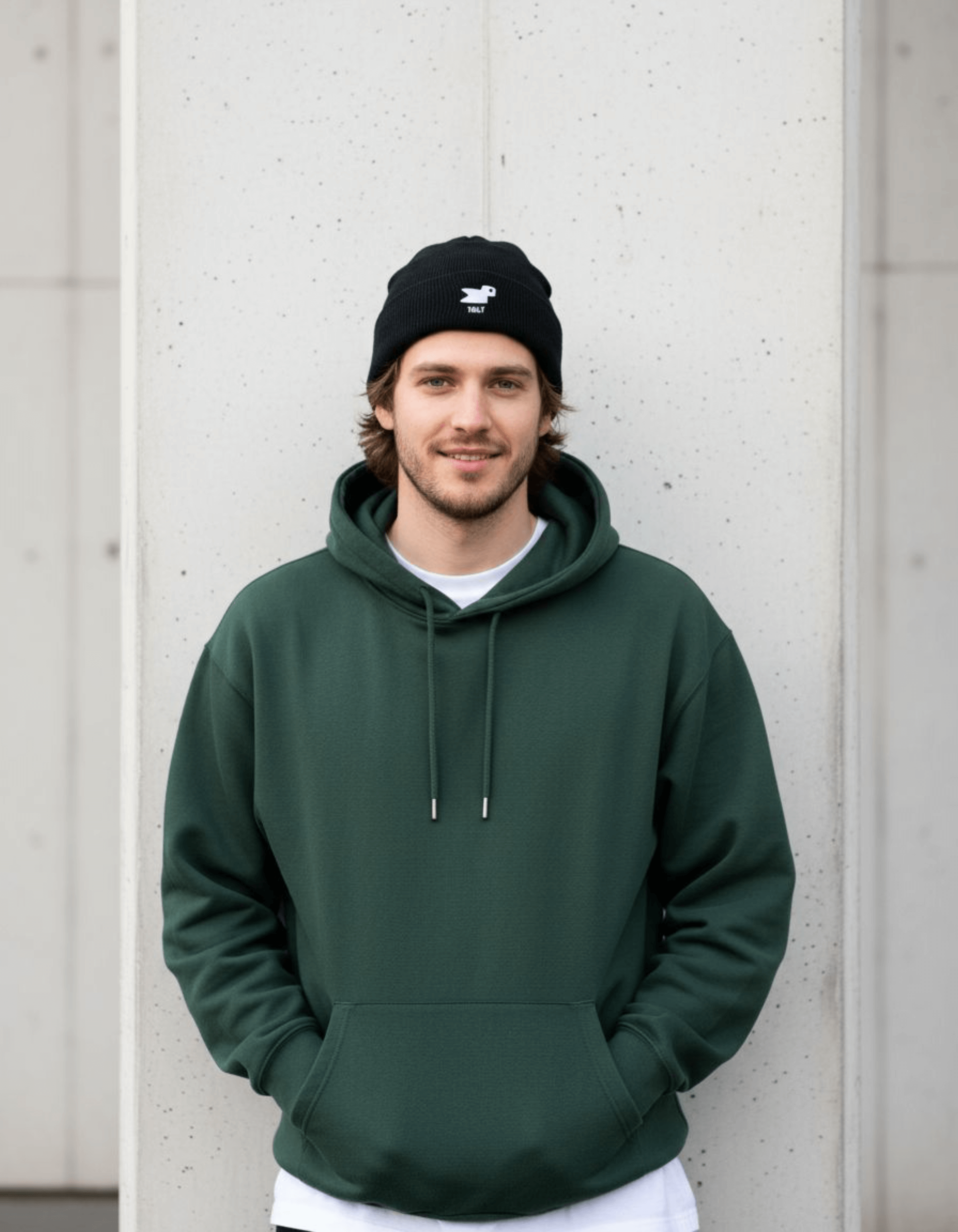 Model wearing a Taily Bird Knit Beanie and green hoodie, showcasing streetwear style.