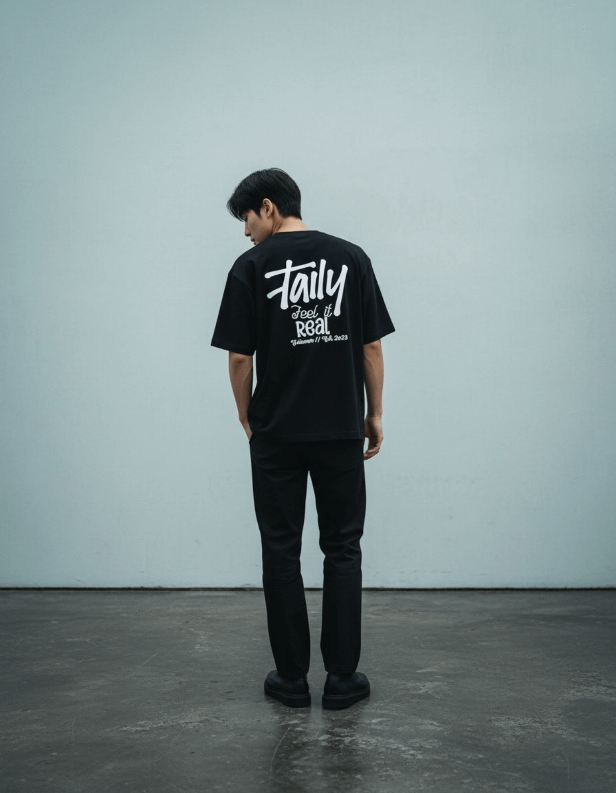 Model wearing Taily Feel It Real Boxy Tee – Black, a stylish streetwear boxy t-shirt with bold lettering.