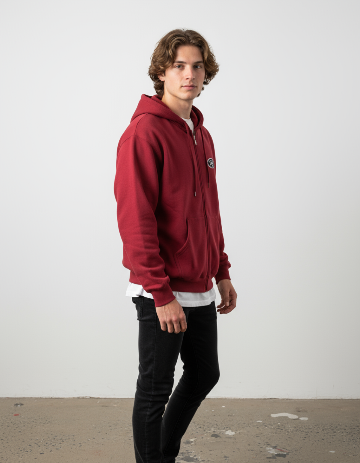 Model wearing Taily Zip Hoodie in cardinal red, showcasing classic embroidered streetwear style and relaxed fit.