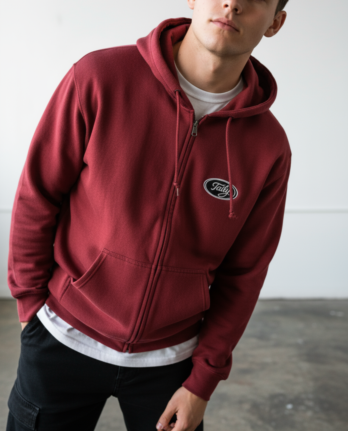 Taily Zip Hoodie in cardinal red with embroidered logo worn by model, showcasing classic streetwear style and comfort.