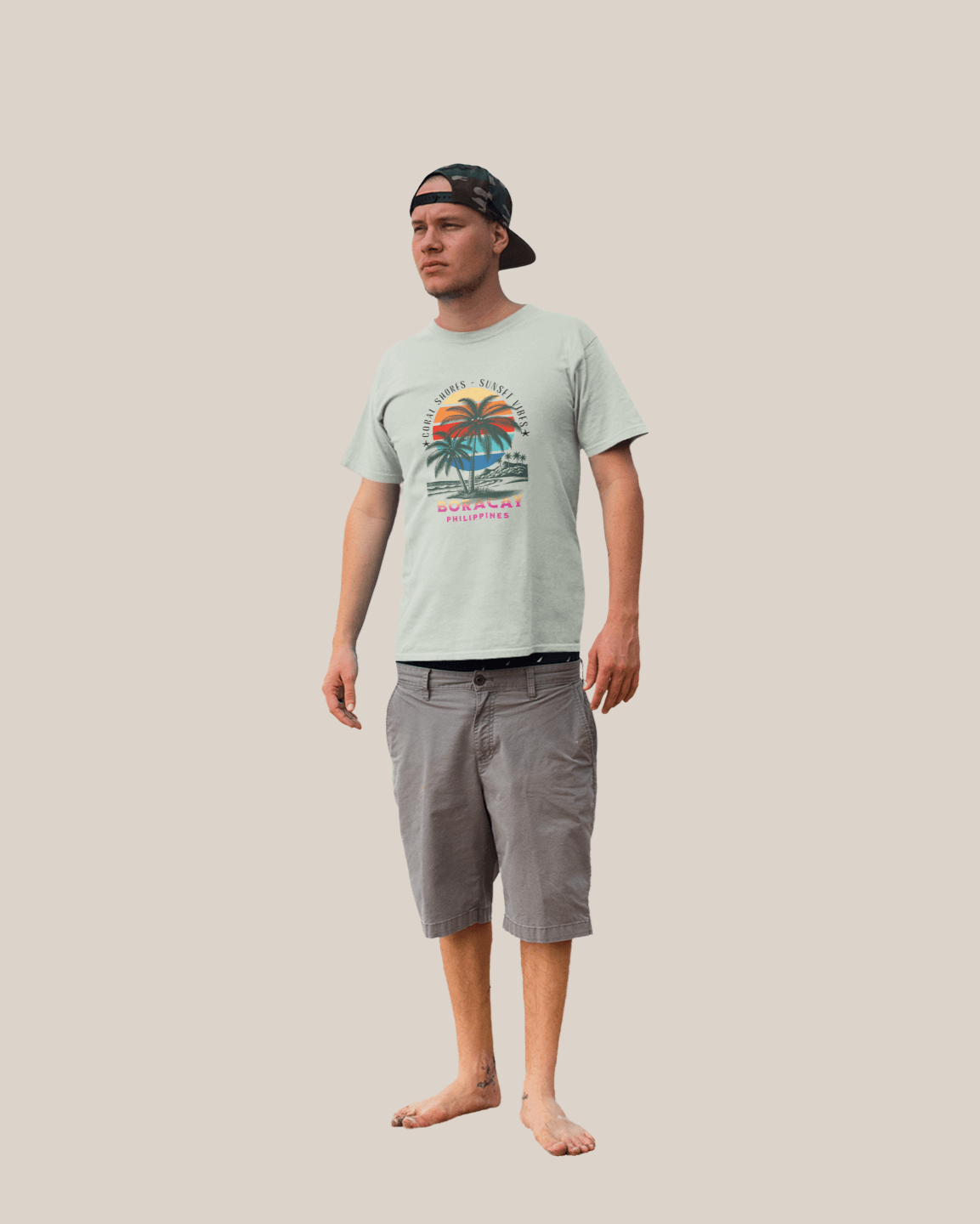 A man wearing a Boracay Sunset Vibes T-shirt and shorts, embodying tropical beach vibes and summer spirit.