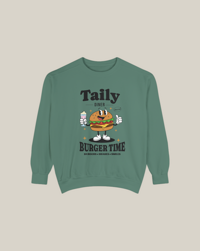 Light green Taily Diner Burger Time sweatshirt featuring a cheerful burger mascot and slogan Burgers • Shakes • Smiles.
