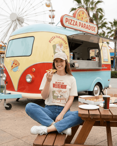 Oversized Pizza T-Shirt – Slice of Weekendin’ (Ecru): woman enjoying pizza at a colorful food truck.