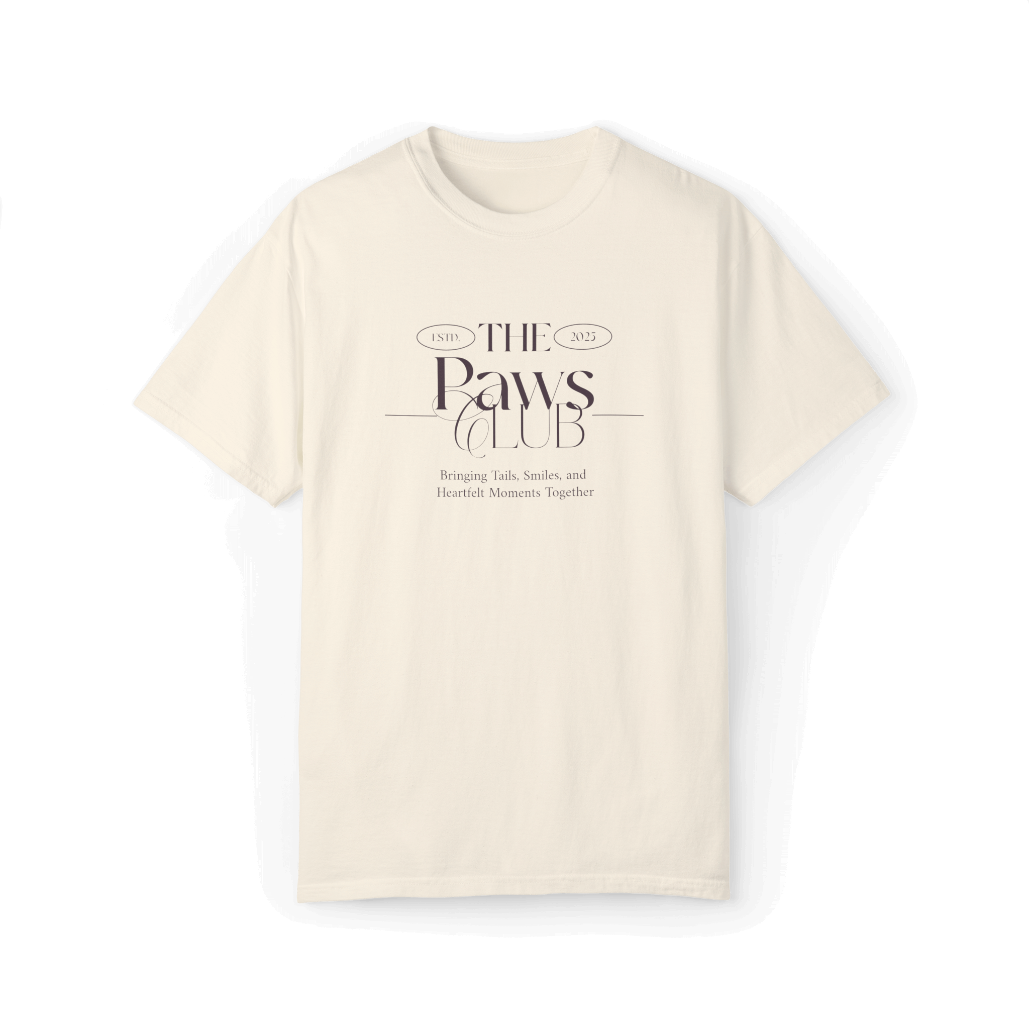 Beige T-shirt featuring 'The Paws Club' logo in elegant typography with the tagline 'Bringing Tails, Smiles, and Heartfelt Moments Together,' emphasizing a classic and minimalist style.