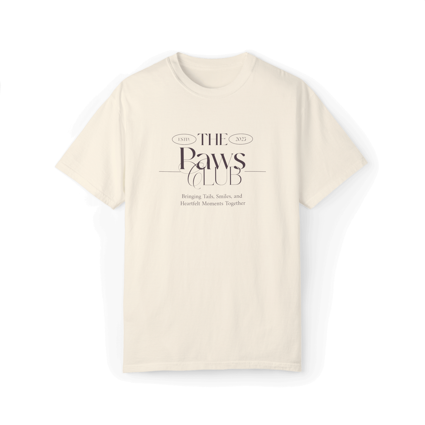 Beige T-shirt featuring 'The Paws Club' logo in elegant typography with the tagline 'Bringing Tails, Smiles, and Heartfelt Moments Together,' emphasizing a classic and minimalist style.