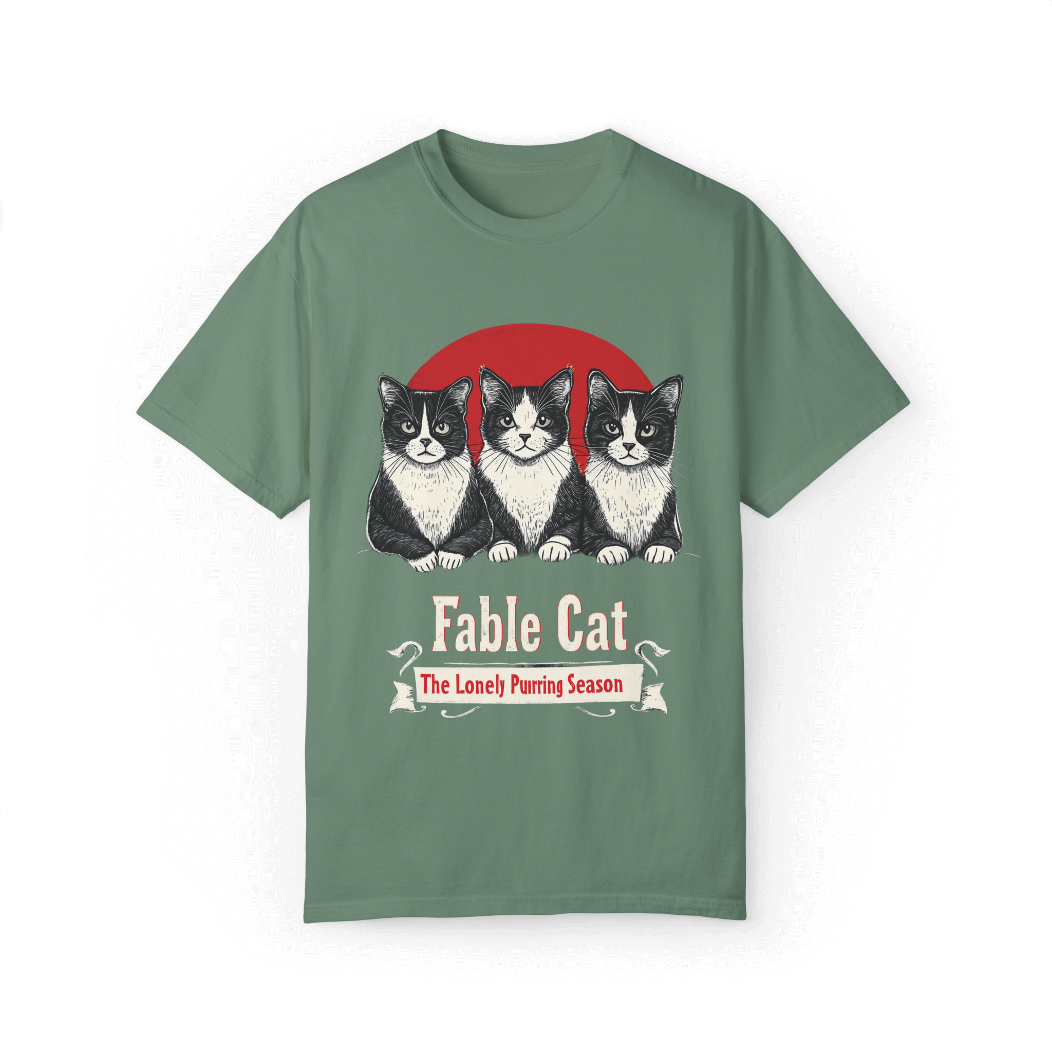 Green T-shirt featuring a 'Fable Cat' design with three black-and-white cats in front of a red circle, accompanied by the tagline 'The Lonely Purring Season.