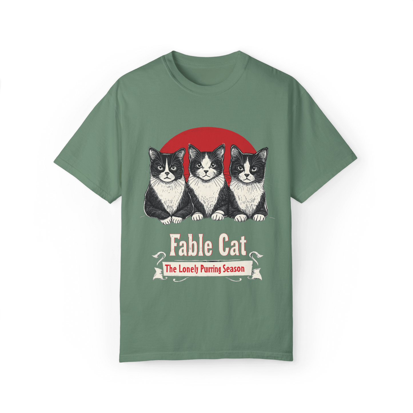 Green T-shirt featuring a 'Fable Cat' design with three black-and-white cats in front of a red circle, accompanied by the tagline 'The Lonely Purring Season.