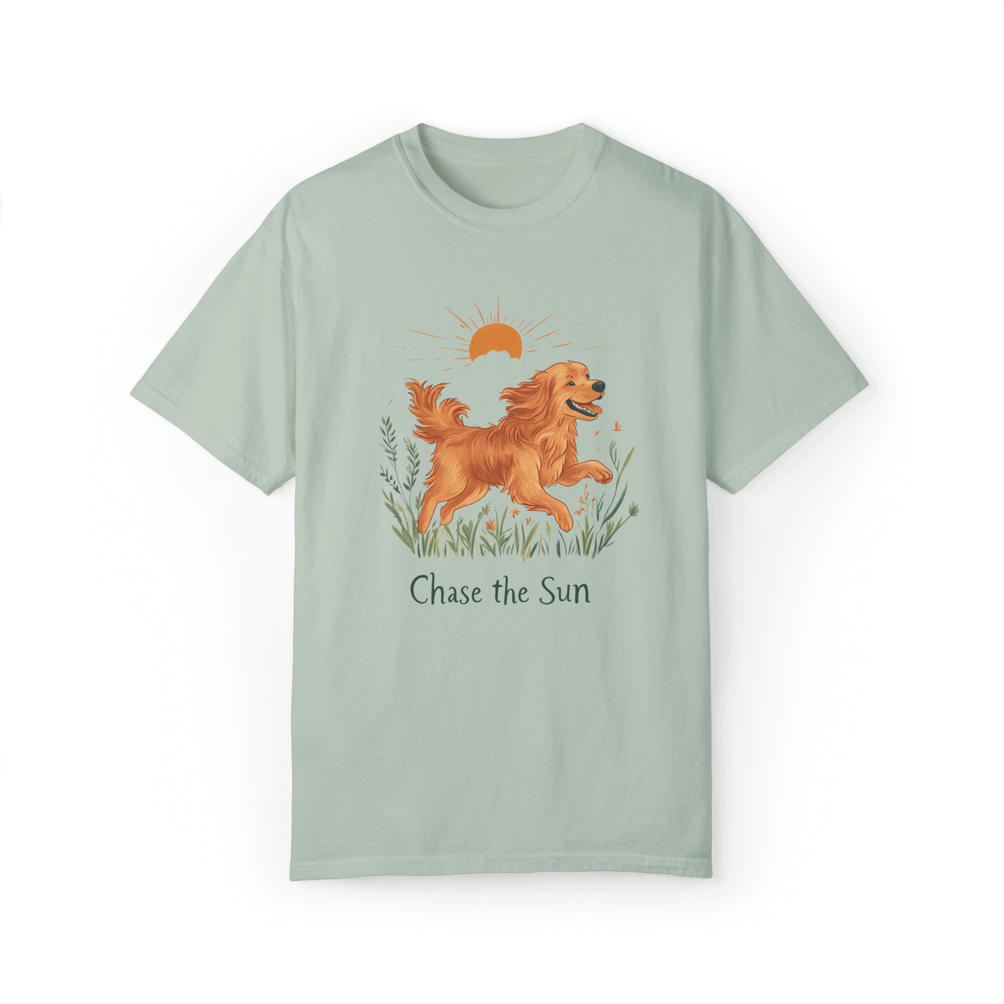 A light green T-shirt featuring an illustration of a running golden retriever with a warm sun and natural wildflowers in the background, complemented by the text "Chase the Sun," reflecting a lifestyle of freedom and sunshine.