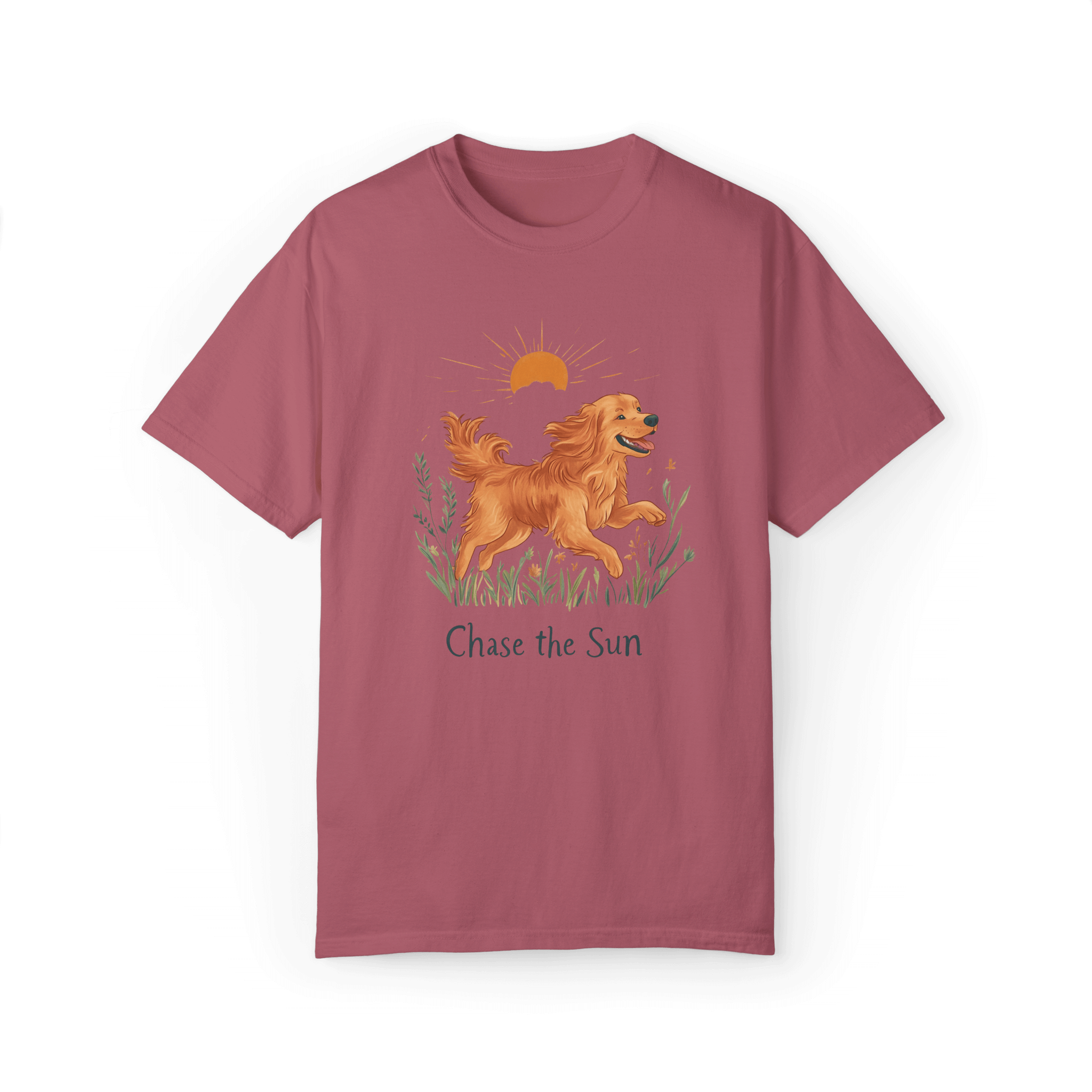 A crimson T-shirt featuring an illustration of a running golden retriever with a warm sun and natural wildflowers in the background, complemented by the text 