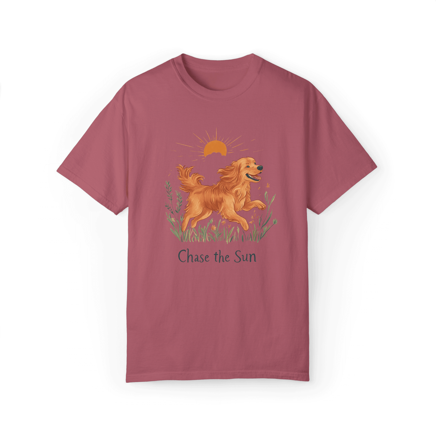 A crimson T-shirt featuring an illustration of a running golden retriever with a warm sun and natural wildflowers in the background, complemented by the text "Chase the Sun," reflecting a lifestyle of freedom and sunshine.