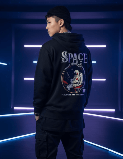 Model wearing Taily “Space Club” Streetwear Graphic Hoodie in black with astronaut design.