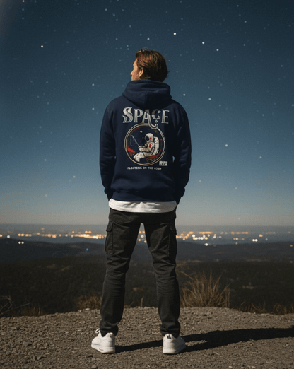 Person wearing Taily Space Club Streetwear Graphic Hoodie, facing stars with astronaut design, navy color.