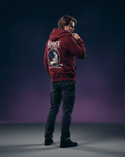 Taily Streetwear Graphic Hoodie in burgundy featuring astronaut graphic and the phrase 'Floating in the Void'.