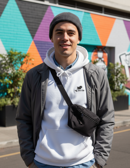 Young man wearing Taily Bird embroidered hoodie and black bag in front of colorful mural.