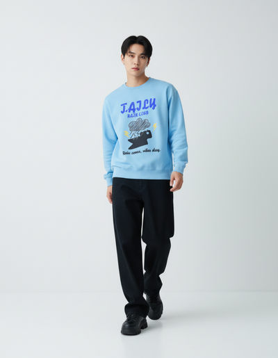 Model wearing a Taily Rain Club sweatshirt in Sky with a graphic design showcasing clouds and lightning.