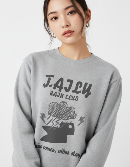 Taily Rain Club sweatshirt in Sport Grey featuring cloud and lightning artwork with the phrase 'Rain comes, vibes stay'.