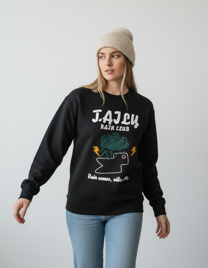 Woman wearing Taily Rain Club sweatshirt in Black featuring weather-inspired graphic and quote.