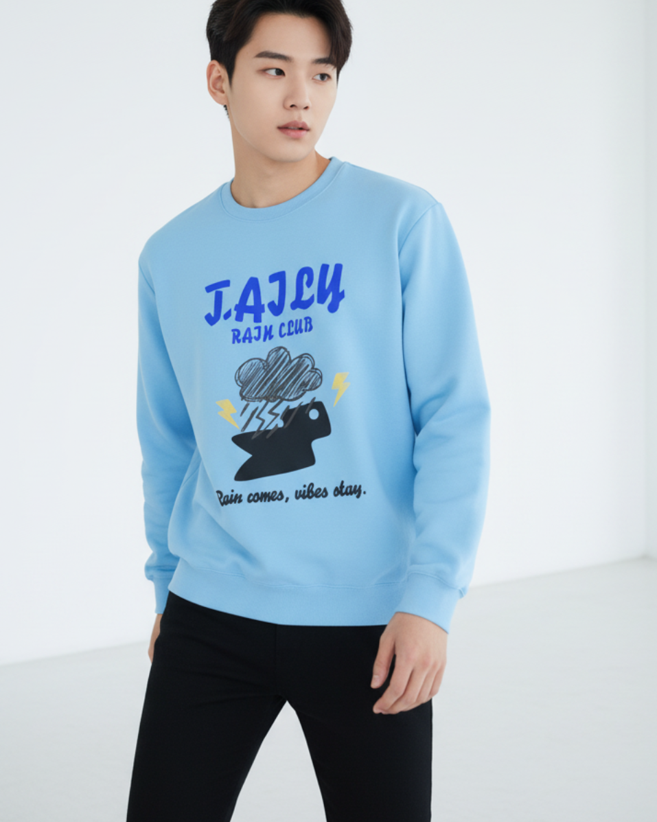 Model wearing Taily Rain Club sweatshirt in Sky with cloud and lightning graphic, featuring the phrase 'Rain comes, vibes stay.'