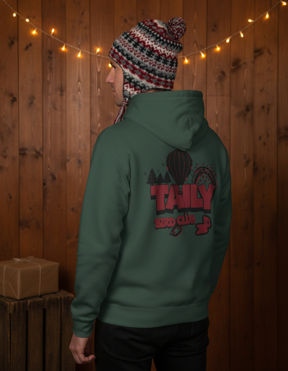 Person wearing Taily Bird Parkland Hoodie in Alpine Green, showing playful graphic design on back.