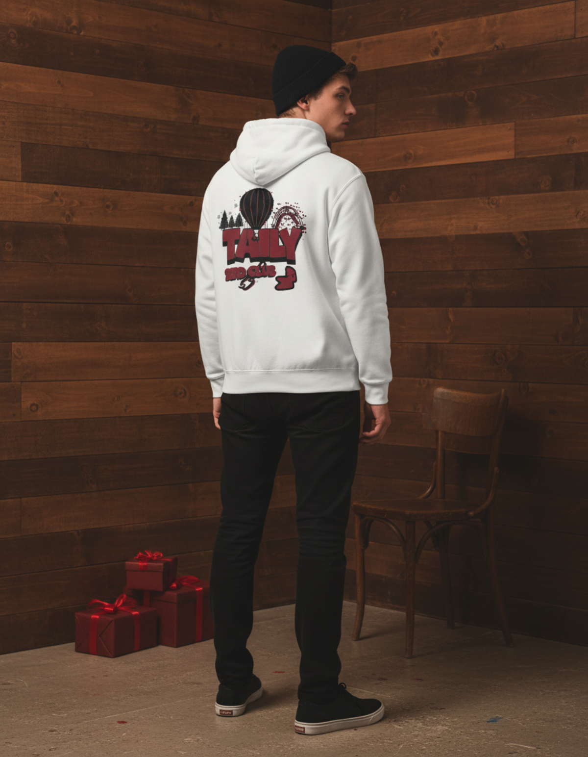 Back view of a model wearing a Taily Bird Parkland Hoodie in white, showcasing the unique design against a wooden wall.