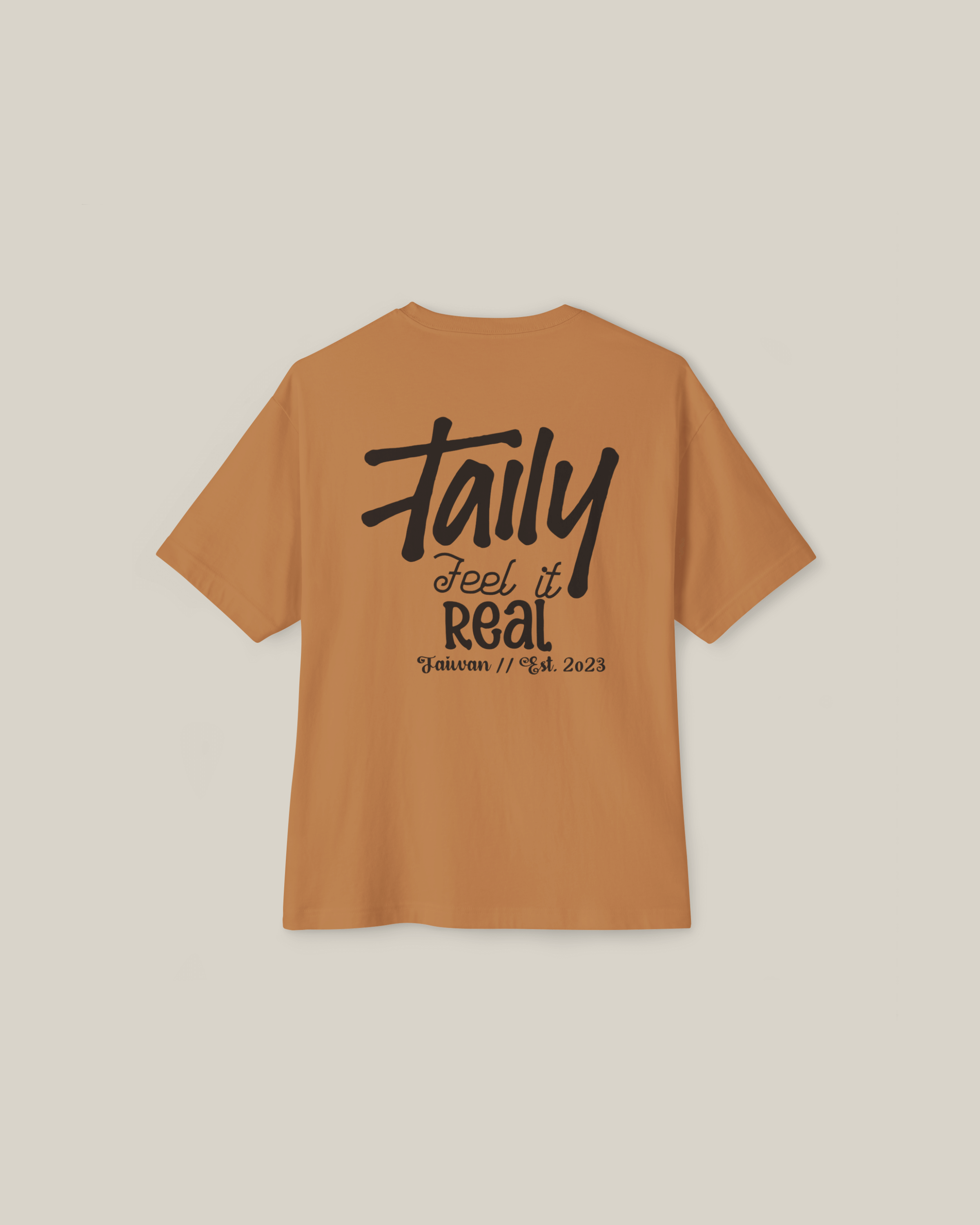 Taily Feel It Real Boxy Tee in toast color featuring bold back lettering and chest logo, perfect for streetwear style.
