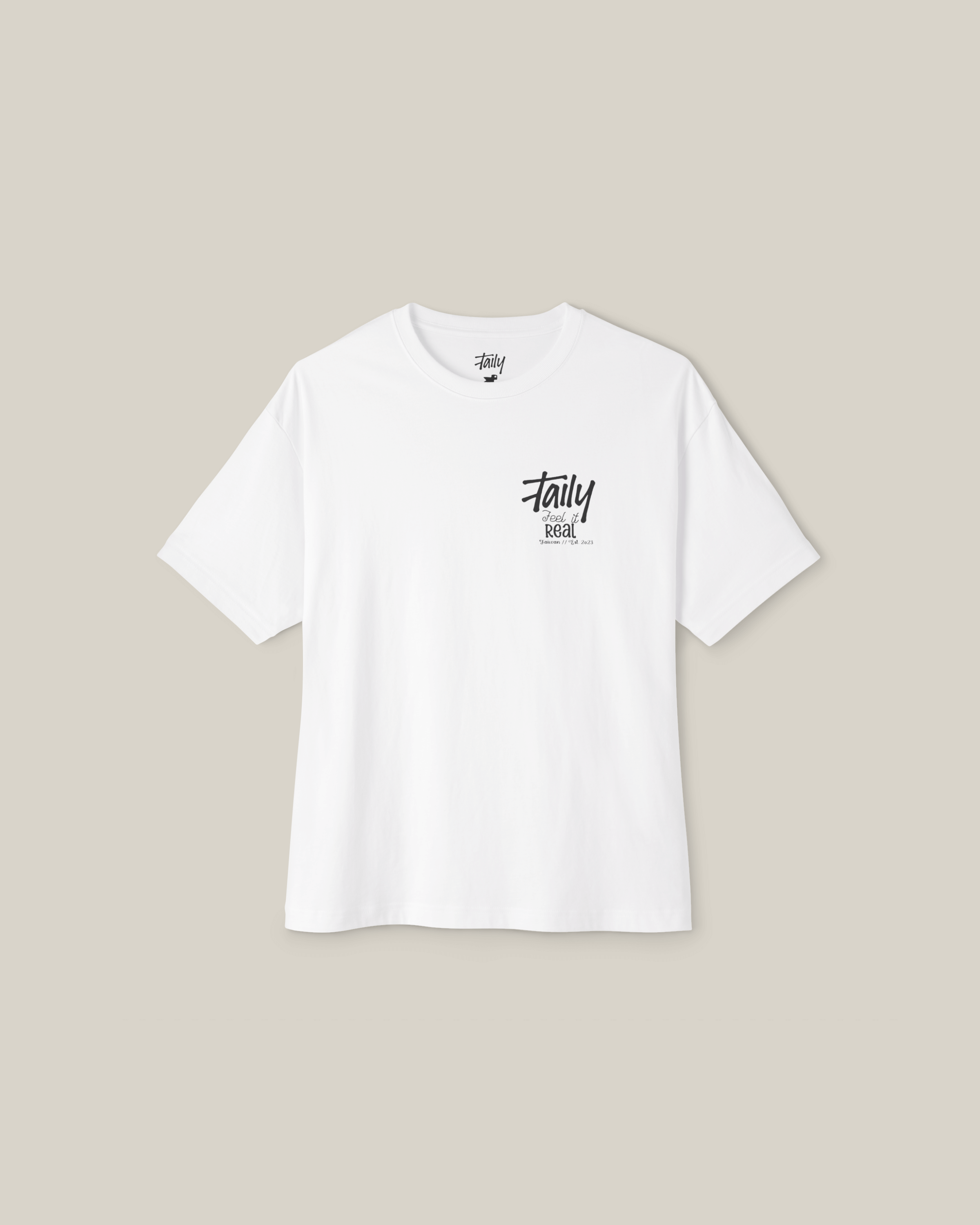 Taily Feel It Real Boxy Tee in white featuring chest logo and bold lettering on the back, showcasing streetwear style.