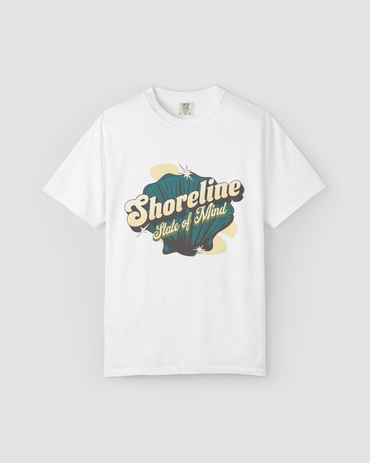 Shoreline State of Mind Tee – White featuring a vintage seashell graphic in deep teal and warm cream.
