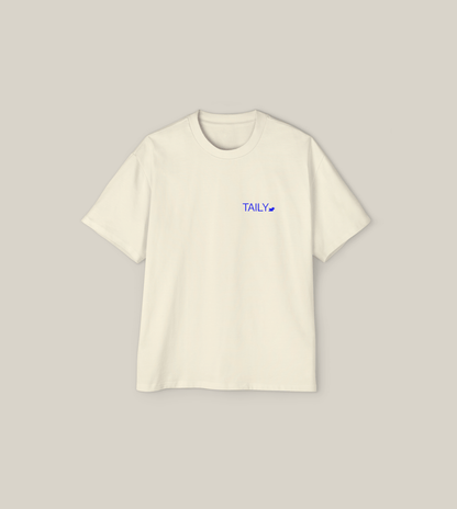 Create Impact oversized tee in cream with blue 'TAILY' logo, perfect for inner growth and transformation.