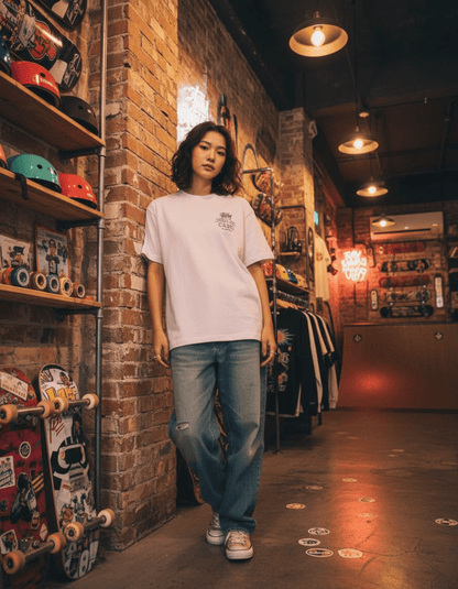 Woman wearing Taily Concrete Waves Taipei Streetwear Boxy T-Shirt in a skate shop with skateboards on display.