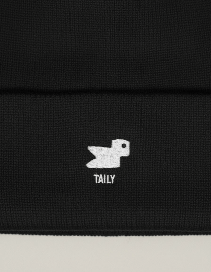 Taily Bird Knit Beanie – Black close-up showing the minimal embroidery detail of the logo.