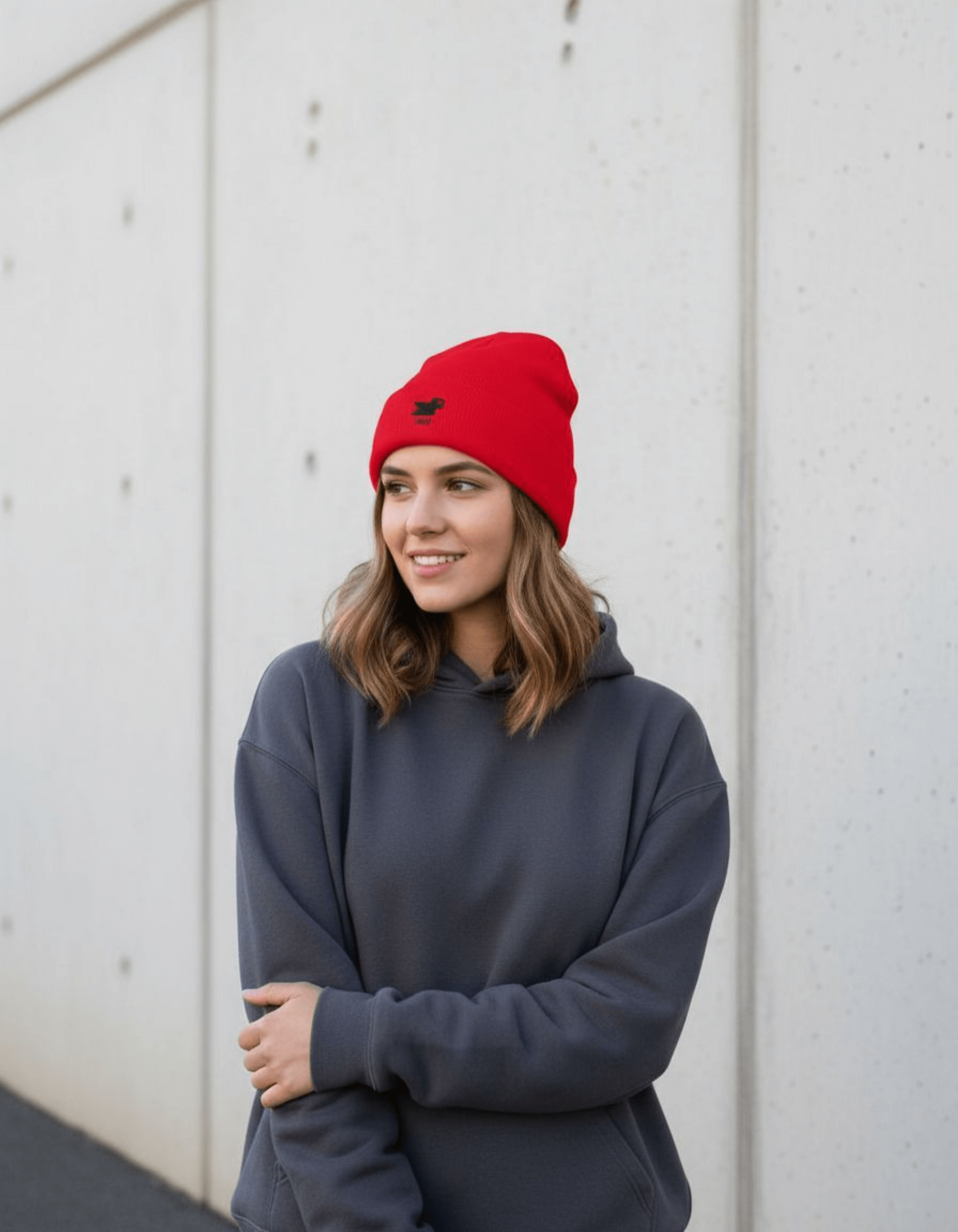 Woman wearing a red Taily Bird Knit Beanie, smiling in a cozy streetwear style.