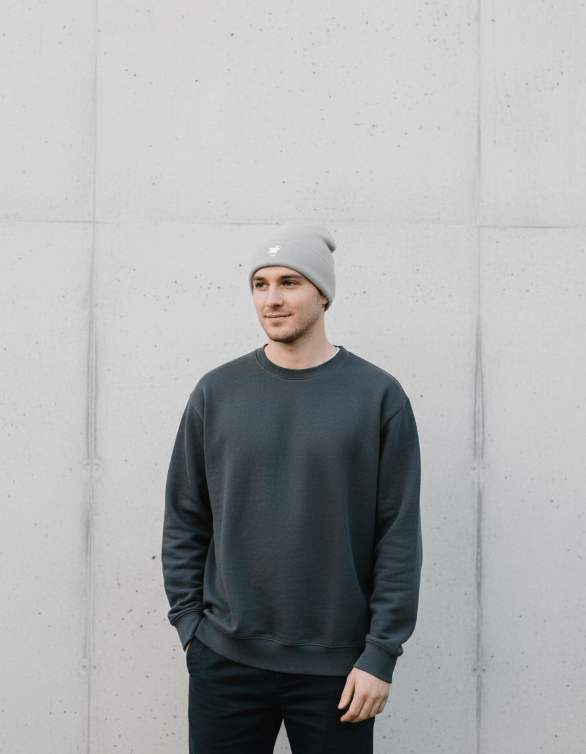 Taily Bird Knit Beanie – Gray worn by a man in casual outfit against a minimalist background.
